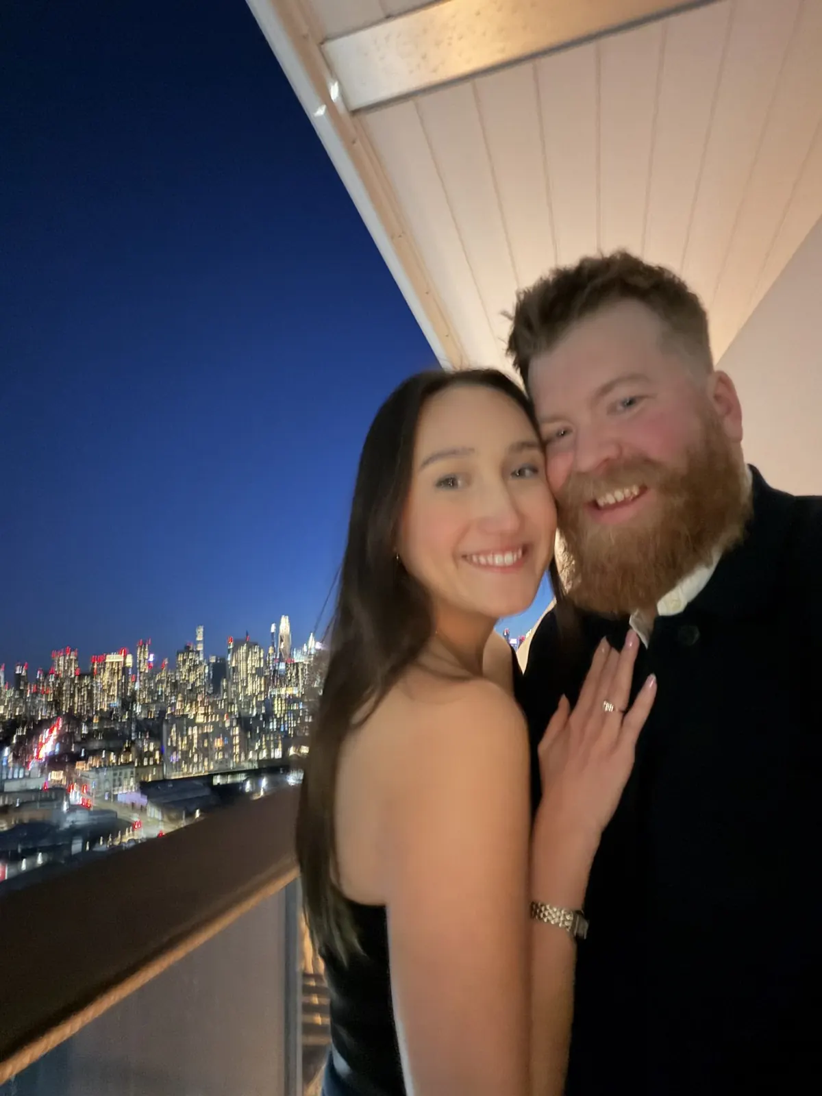 Lucie and Simon at night, Manhattan lit up behind them
