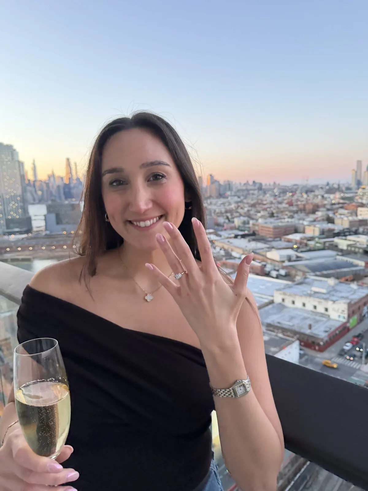 Lucie showing her engagement ring against the New York skyline